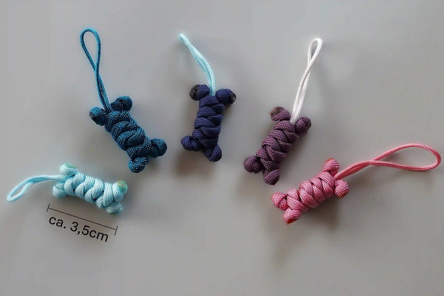 Fünf bunte Schlüsselanhänger aus geflochtenem Paracord in verschiedenen Farben mit Schlaufe am oberen Ende