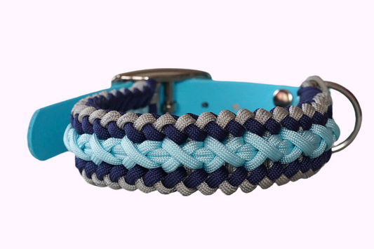 Geflochtenes Hundehalsband aus dunkelblau, hellblauen und grauen Bändern mit silberner Metallschnalle und Löchern zur Größeneinstellung.