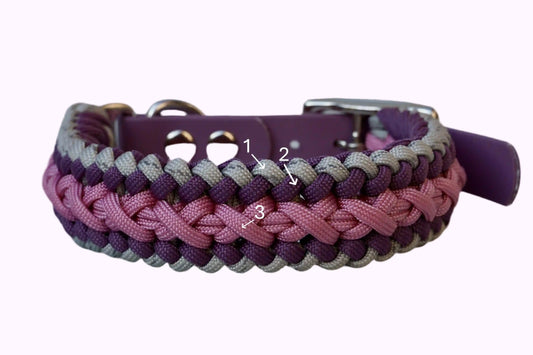 Geflochtenes Hundehalsband aus lila, rosa und grauen Bändern mit silberner Metallschnalle und Löchern zur Größeneinstellung.