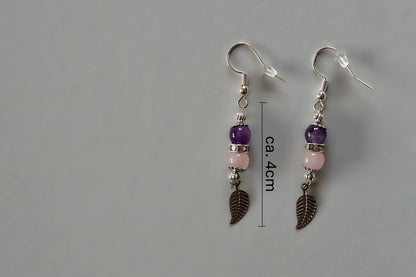 Ohrringe mit silberfarbenen Haken, zwei Edelsteinperlen in Amethyst und Rosenquarz sowie einem silberfarbenen Blattanhänger mit Maßstab