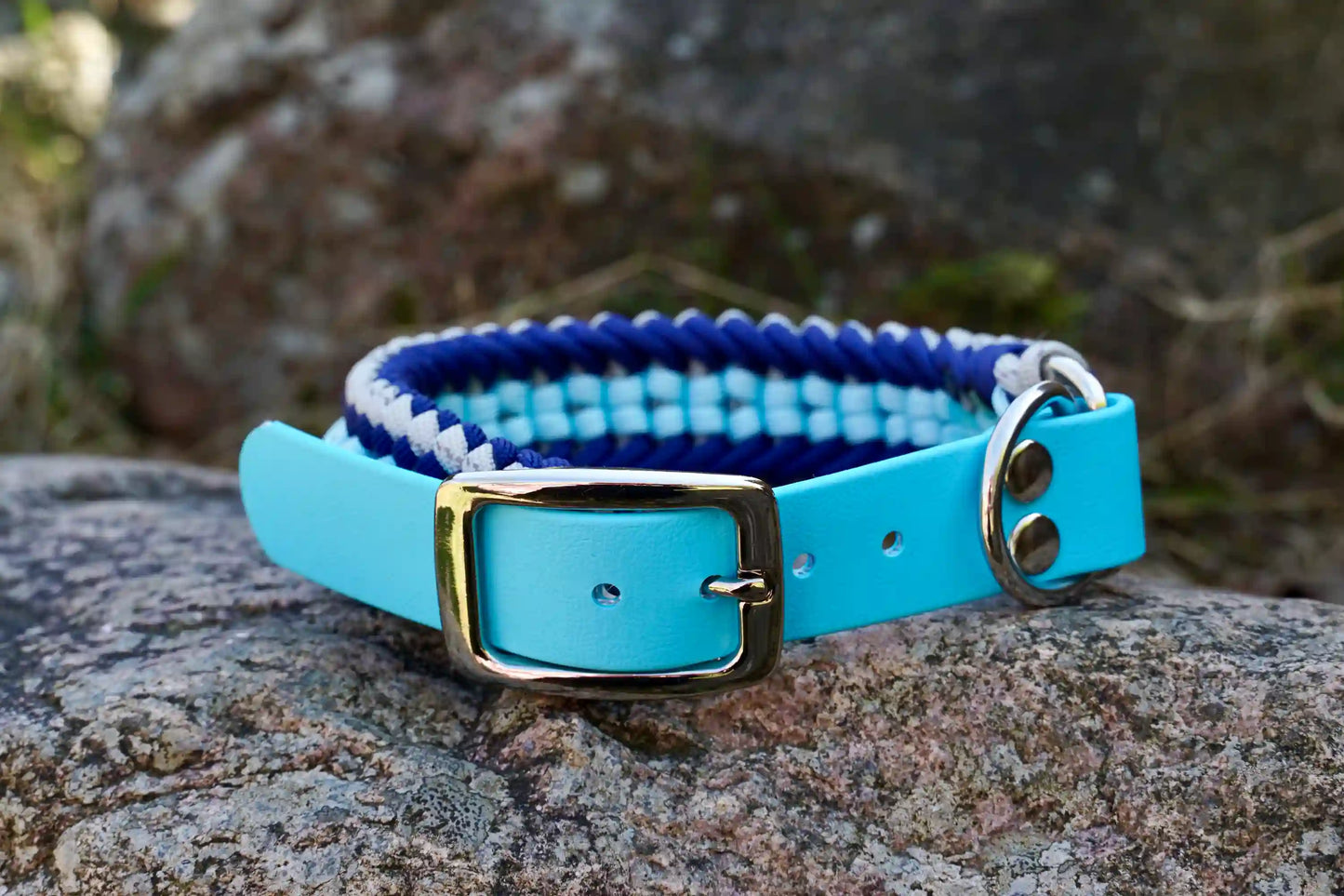 Geflochtenes Hundehalsband aus dunkelblau, hellblauen und grauen Bändern mit silberner Metallschnalle und Löchern zur Größeneinstellung.