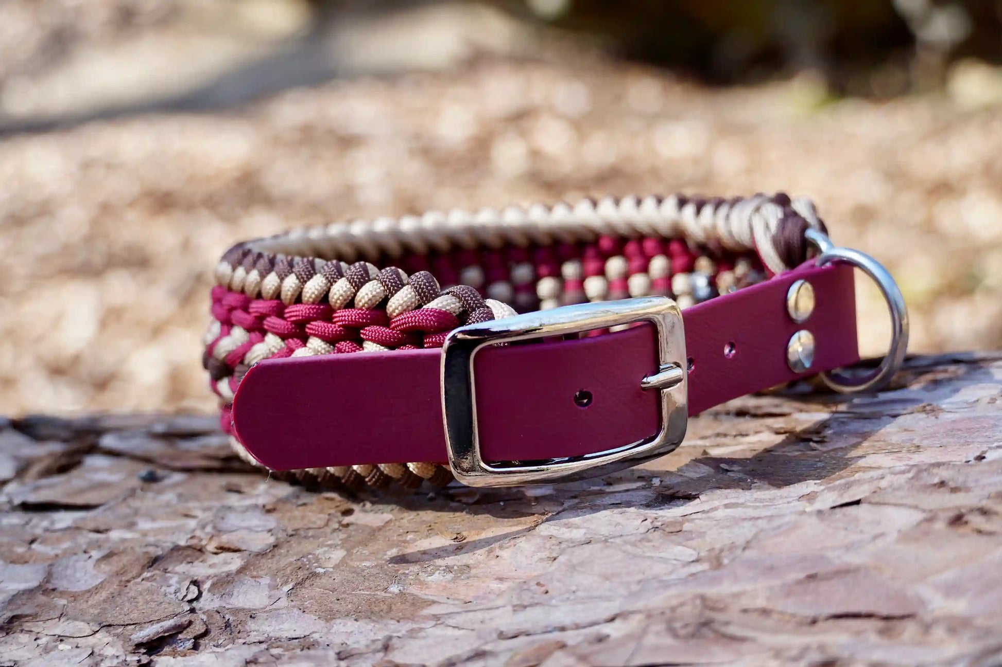 Geflochtenes Hundehalsband aus braunen, weinroten und goldenen Bändern mit silberner Metallschnalle und Löchern zur Größeneinstellung.
