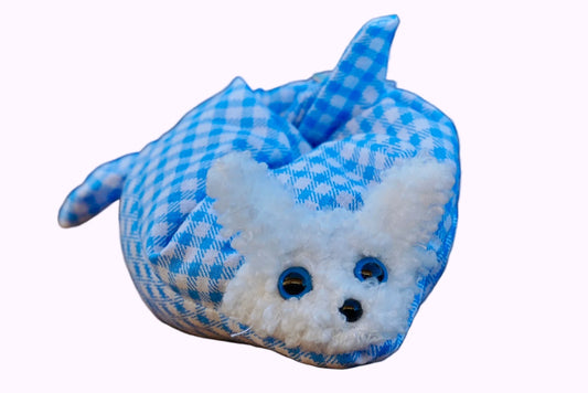 Kuscheltier in Form eines weißen Hasenkopfes mit blauen Knopfaugen, eingewickelt in blau-weiß karierten Stoff
