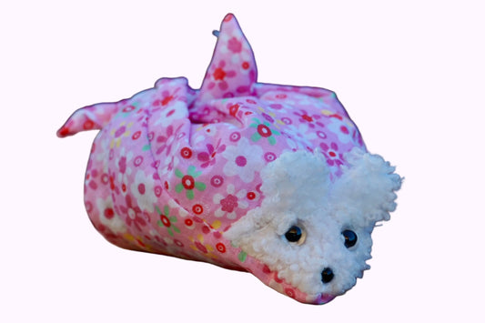 Kuscheltier in Form eines weißen Hasenkopfes mit Knopfaugen, eingewickelt in rosa  Blümchenstoff