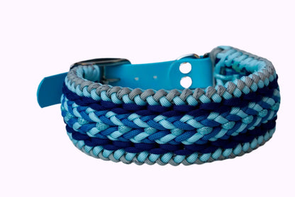 Geflochtenes Hundehalsband aus dunkelblau, hellblauen und grauen Bändern mit silberner Metallschnalle und Löchern zur Größeneinstellung.