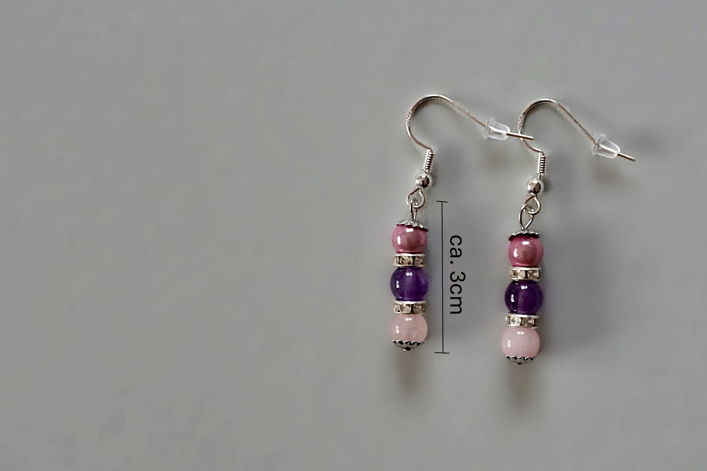 Ohrringe mit silberfarbenen Haken, zwei Edelsteinperlen in Amethyst und Rosenquarz, sowie rosa Acrylperle mit Maßstab