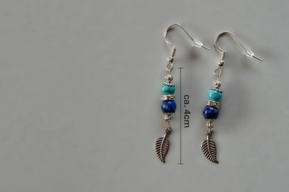 Ohrringe mit silberfarbenen Haken, zwei Edelsteinperlen in Turquenit und Sodalith sowie einem silberfarbenen Blattanhänger mit Maßstab