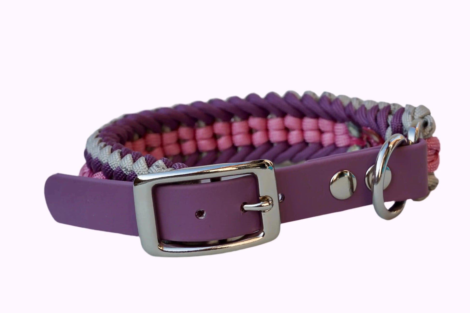 Geflochtenes Hundehalsband aus lila, rosa und grauen Bändern mit silberner Metallschnalle und Löchern zur Größeneinstellung.