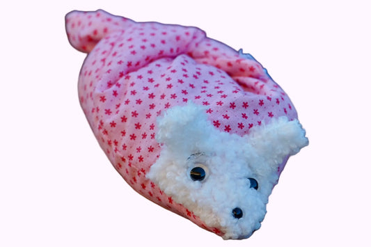 Kuscheltier in Form eines weißen Hasenkopfes mit Knopfaugen, eingewickelt in rosa Stoff mit Sternen 